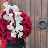 caja elegante de rosas rojas con orquideas blancas