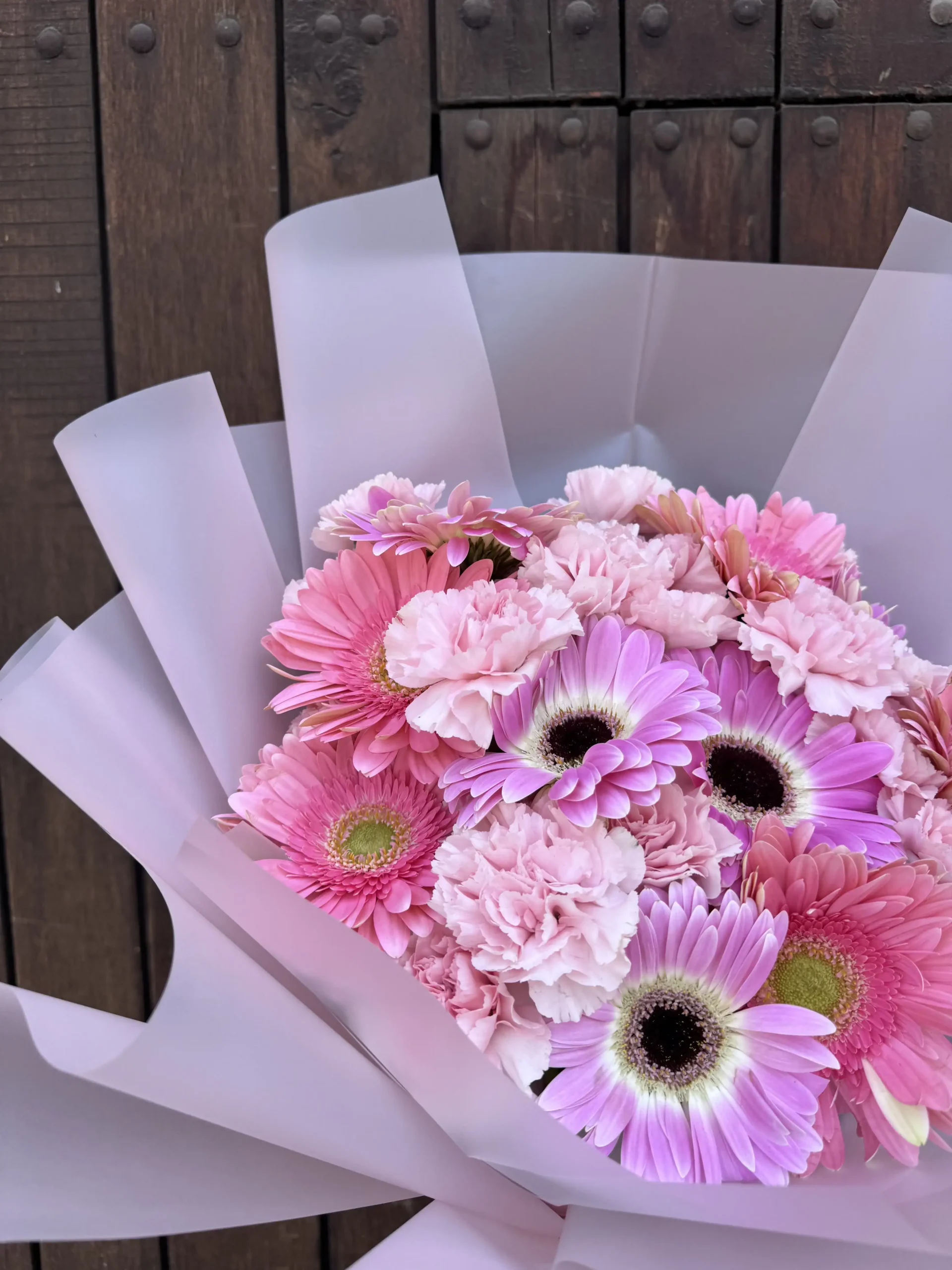 ramo de gerberas con claveles envueltos en papel especial con tecnica coreana